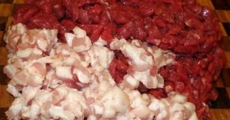 We boil the rice until half cooked. The meat is cut into pieces and ground in a meat grinder. Add salt, pepper and crush with your hands.