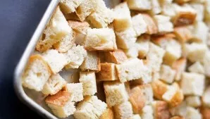 Cut a few slices of bread into cubes and arrange them on a baking sheet. If desired, you can add salt, season with spices and drizzle wit...