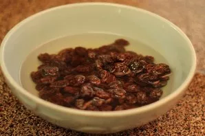 First you need to pour the raisins with hot water and leave for 5-7 minutes. Then drain the water and drain the raisins.