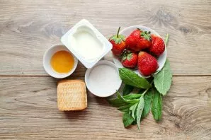 Prepare all the necessary ingredients for making strawberry and biscuit yogurt dessert.