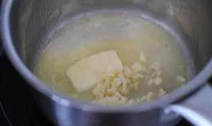 Melt the butter in a pot, then add finely chopped garlic to it and simmer for a couple of minutes on low heat. The garlic should give a p...