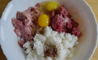 In a deep bowl, mix the boiled rice, pork mince, eggs, salt and spices.