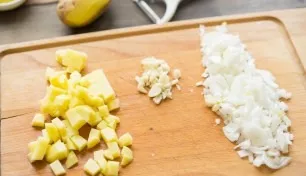 Wash the potatoes, peel them and cut into cubes. Also chop the onion and garlic.