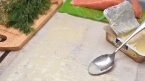 I take out the lavash from the package and unwrap it on the table. I have the melted cheese spreadable, so I distribute it over the entir...