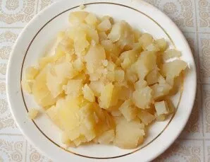 Boil the potatoes with the peels, remove the skins. When the potatoes have cooled, cut them into small cubes.