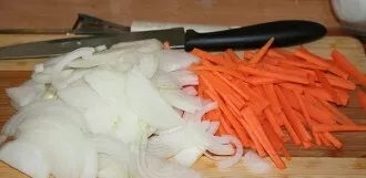 Sort the groats in advance. Then soak in water for 2 hours. Cut the onion for porridge into half rings, and the carrots into strips.