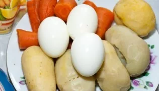 Pre-boil potatoes and carrots with skin. Boil the eggs hard.