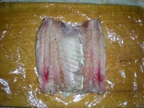 First you need to clean the herring and remove all the bones to get a clean fillet. Put a small piece of cling film on the table and put ...