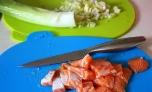 Rinse the leek and chop. Salmon fillet is cut into portions.