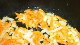 Pour vegetable oil into the pot. We clean all the vegetables and chop them finely. Three carrots are grated. Fry the vegetables until hal...