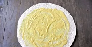 Place the tortilla on the countertop and coat with your favorite sauce.