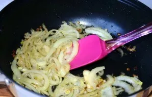 Fry the onion in half rings in vegetable oil until golden brown.