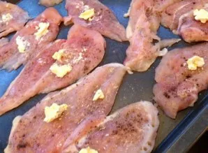 Cut the chicken breasts lengthwise into two halves, knock them out and put them on a baking sheet. Salt and pepper, as well as put a piec...