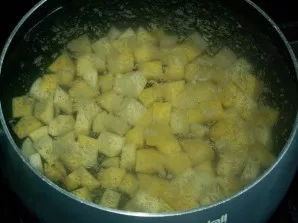 Wash the potatoes, peel, chop and throw them in salted water to boil.