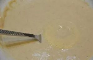 Dip the apple ring in the dough with a fork.