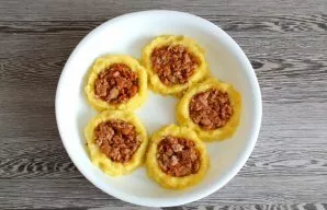 Add the meat filling, lightly pressing it with a spoon.