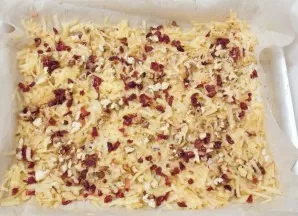 Spread the roasted nuts on the layer of apples with cranberries.