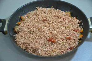 Add rice to the meat and fry together with the meat for a few minutes.
