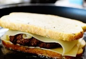 On top there is another slice of cheese and a slice of bread.