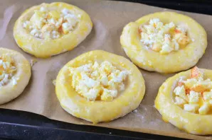 Lay out the filling and grease the cheesecakes with egg yolk. Place in an oven preheated to 180 degrees.