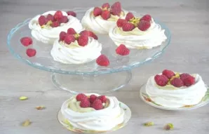 Decorate pavlova cakes with fresh raspberries and serve.