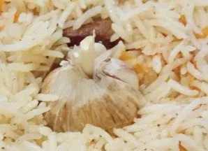 Wash the head of garlic and put it in the middle of the rice.