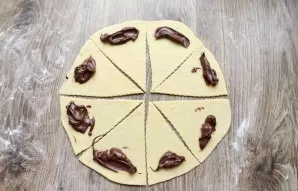 Place nutella on the wide edges of the triangles. Roll from the wide edge to the narrow edge. Pinch the edges to prevent the nutella from...