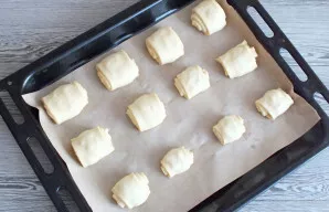 Line the baking sheet with baking paper. Put the prepared rolls, cover with a towel and leave for 20 minutes. Then place in an oven prehe...