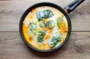 Put fried vegetables on top and pour sour cream diluted with water. Season everything with salt, pepper and cover with a lid.