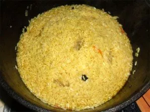 When the liquid boils and the rice comes to the surface, we push it into a small pile. With the handle of the spoon we make a few holes t...