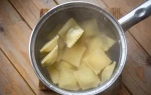 Boil 1-2 liters of water in a saucepan and put a batch of prepared ravioli in actively boiling water. Boil ravioli for 7-8 minutes.