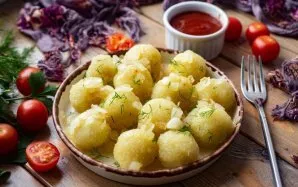 Lay out the dumplings of boiled potatoes on a plate, put the fried onion and vegetable oil on top. The dish is ready! Serve.