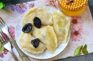 Serve the prepared dumplings with prunes on the table, pouring a lot of honey to make the dish sweet.