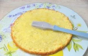 To assemble the cake, place the first biscuit on a plate. Brush it with peach syrup. If the syrup is very sweet, it can be diluted with b...