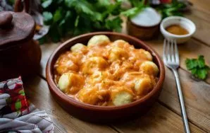 Pour the prepared sauce into the potato balls on the plate and serve immediately.