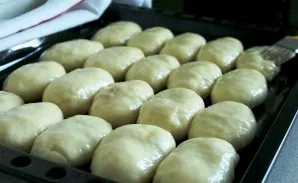 Grease the buns with a beaten egg.