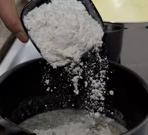 Add the flour and mix quickly to avoid lumps.