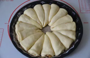 Place the croissants in a form with a diameter of 25-27 cm, anointed with butter and sprinkled with flour. Let it rise for 40-50 minutes.