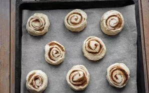 Roll the dough into a roll and cut into equal parts with a knife, put these parts with the cut side up on a baking sheet lined with bakin...
