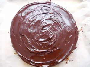 Remove the cake from the refrigerator and completely cover with chocolate icing.