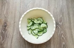 Wash the cucumbers, dry them and cut them into half rings, put them in a salad bowl.