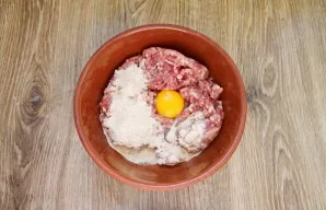 Add minced meat, bread crumbs and beat in an egg in a bowl.