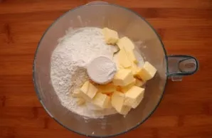 First, prepare the dough. To do this, mix flour, salt, sugar and diced butter in a food processor.