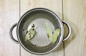 Pour water into the pot, add bay leaf and spices.