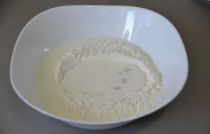 Pour flour into the kneading bowl, make a well in the middle, pour warm milk into it, add sugar, salt, knead the yeast and leave for 10-1...