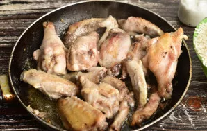 Heat vegetable oil in a pan and fry the chicken pieces.