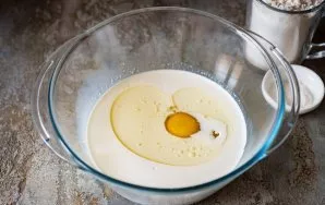 Pour cream into a bowl, pour in vegetable oil, sugar and beat the egg.