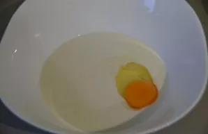 Break an egg into a bowl and pour 1 cup of milk.