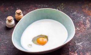 Pour milk into a deep bowl, beat one egg.
