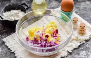 Peel and wash the potatoes, grate with a fine grater. Peel the onion and cut into small cubes, put in a bowl with potatoes.